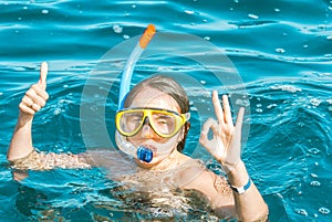 young girl is enjoying diving in the blue sea