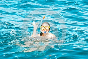 young girl is enjoying diving in the blue sea