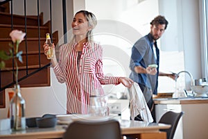 A young girl enjoying when her boyfriend doing housework. Kitchen, housework, home, relationship