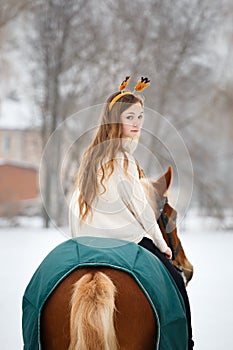 Young girl enjoying horseback riding in winter