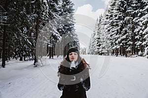 Young girl enjoying hot tea in the winter forest