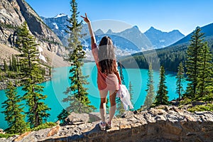 Young girl enjoying Moraine Lake beautiful scenery. Banff National Park nature landscape. Canadian Rockies summer time.