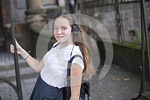 Young girl enjoying music in headphones on the street. Happy.