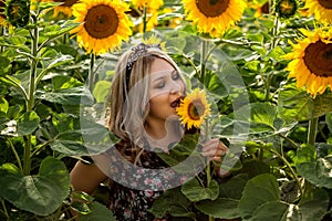 Young girl enjoying nature on the field of sunflowers.