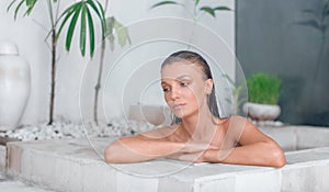 Young girl enjoys spa treatments in the bathroom with flowers