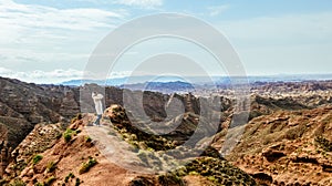 Young girl enjoys the view of valley on top of hill