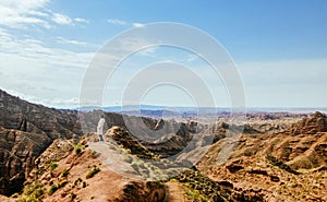 Young girl enjoys the view of valley on top of hill