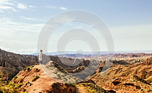 Young girl enjoys the view of valley on top of hill