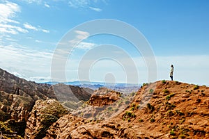 Young girl enjoys the view of valley on top of hill