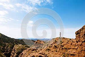 Young girl enjoys the view of valley on top of hill