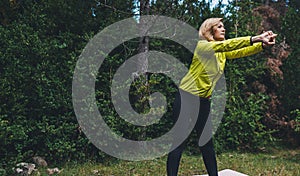 Young girl exercising outdoors, fit woman doing stretching exercises  training outside in green park. Sport woman play yoga