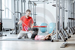 Young girl exercising with trainer at the rehabilitaion gym