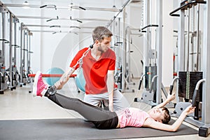 Young girl exercising with trainer at the rehabilitaion gym
