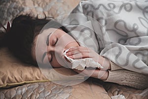 Young girl experiencing discomfort from a runny nose holding a handkerchief in the face