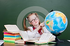 Young girl exploring the globe in classroom