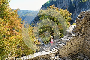 Young girl exploring Monodendri village with its traditional stone-made buildings and stone walkways, Zagoria area, Epirus, north-