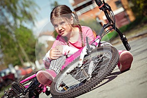 Young girl fell from the bike in a park