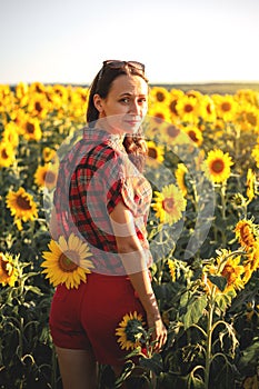 A young girl in a field of sunflowers at sunset