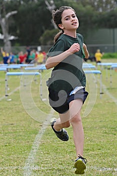 Young girl finishing a hurdle run