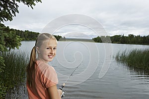 Young Girl Fishing At Lake