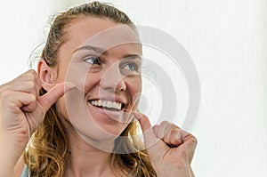 Young girl flossing her teeth