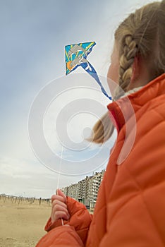 Young girl flying a kite on the beach