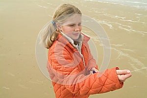 Young girl flying a kite on the beach