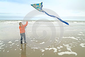 Young girl flying a kite at the coastline