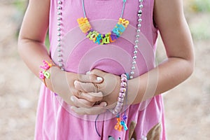 A young girl folding her hands