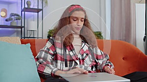 Young girl freelancer lying on couch closing laptop pc after finishing work in living room at home