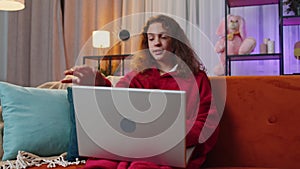 Young girl freelancer sitting on couch closing laptop pc after finishing education in room at home