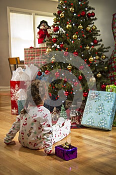 Young girl in front of Christmas tree.
