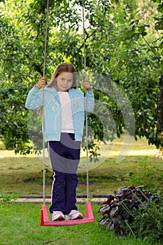 Young girl on the garden swing