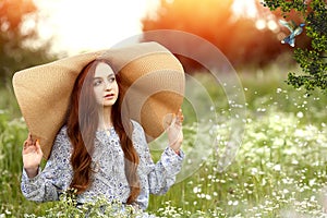 Young girl in the garden where birds. Sunset and wildflowers. Fairy tale and magic concept
