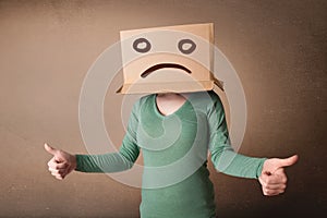 Young girl gesturing with brown cardboard box on her head with s