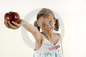 Young girl giving an apple