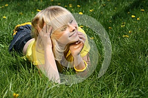 Young girl on a glade of dandelions