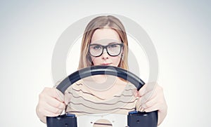 Young girl in glasses with steering wheel, auto concept