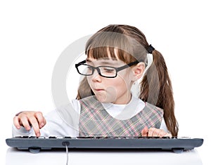 Young girl with glasses typing keyboard. isolated on white background