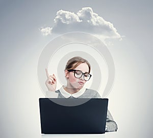 Young girl in glasses works at a laptop showing thumb up on the cloud