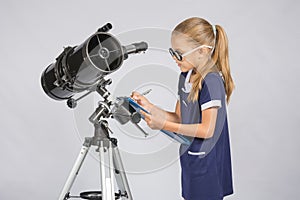 Young girl glasses writes astronomer observations photo