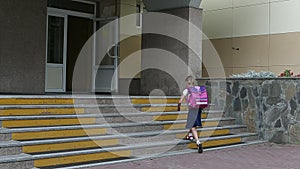 Young girl go to school walking by staircase come in to school entrance. Back to school concept. 1 september girl with