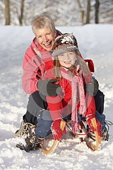 Young Girl With Grandmother Riding On Sledge