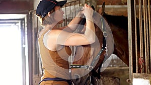 Young girl grooming horse and making braids from mane. in a stable the girl takes care of the brown horse photo