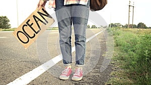 Young girl with a guitar coming along the road