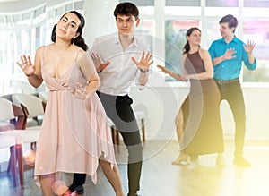 Young girl and guy dancing vintage twist in dance studio