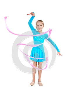 Young girl gymnast exercising with pink ribbon on white