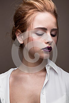 Young girl with a haircut in a white shirt. Beautiful model with nude make-up and bright lips. Office Style