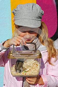 Young girl with hamster in portable transporter