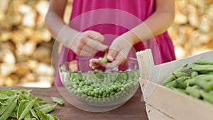 Young girl hands shelling peas - rack focus